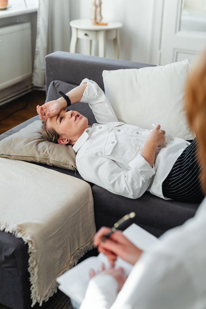 Woman lying on couch during therapy session, expressing concern.